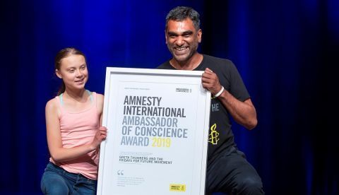 La joven activista sueca Greta Thunberg (i) fue registrada este lunes al posar con el Secretario General de Amnistía Internacional, Kumi Naidoo (d), después de recibir, junto al movimiento estudiantil de activistas contra el cambio climático "Viernes para el Futuro", el premio Embajadora de Conciencia de Amnistía Internacional (AI) de 2019, en Washington DC (EE.UU.) EFE/Erik S. Lesser 	   