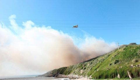 Un hidroavión descarga agua para sofocar un incendio forestal en Galicia. EFE/ Moncho Fuentes