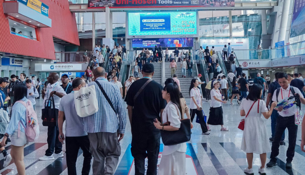  Mucha gente circulando por un espacio con carteles. Feria comercial en Cantón (China). Daniel Pawer/Shutterstock