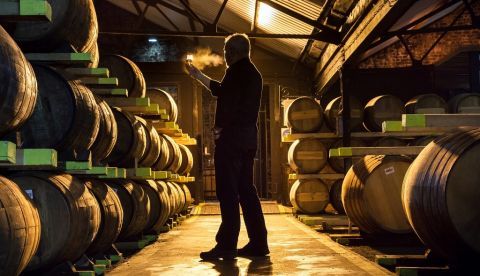 Un hombre sostiene un vaso de whisky en una destilería cerca de Glasgow en Escocia, Reino Unido. EFE/ Robert Perry/Archivo
