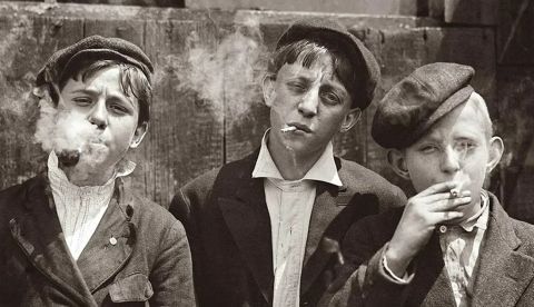 Jóvenes repartidores de periódicos en una pequeña pausa mientras fuman sus cigarrillos. 1910, St. Louis. Lewis Hine. Biblioteca del Congreso de Estados Unidos