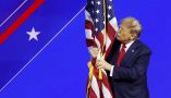 Donald Trump hugs an American flag as he arrives at the Conservative Political Action Conference on Feb. 24, 2024, in Baltimore. Anna Moneymaker/Getty Images