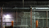 Barbed wire surrounds the GEO Group ICE detention facility in Adelanto, Calif. on July 10, 2025. Patrick T. Fallon/AFP via Getty Images