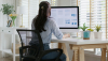  Una mujer vista de espaldas, trabajando en un escritorio en casa Chay_Tee/Shutterstock