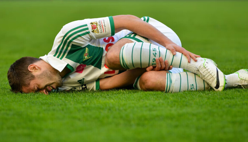 El futbolista Maciej Makuszewski se duele de una lesión durante un partido de la liga polaca de 2014. Shutterstock / Dziurek