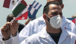  waving cuban doctors in white coats and face masks arrive back in cuba from mexico. Cuban doctors who worked in Mexico during the height of the COVID pandemic return to Havana. Yandry_kw/Shutterstock