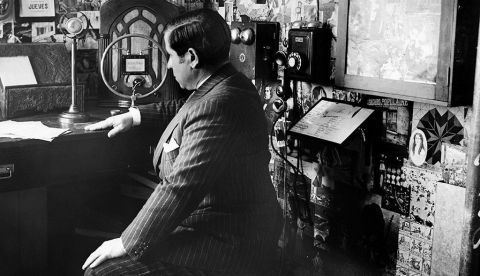Fotografía de los años treinta del escritor Ramón Gómez de la Serna, en su estudio, rodeado de teléfonos, receptores de radio y micrófonos, a través de los cuales difundió sus "Greguerías onduladas" o breves textos en prosa escritos para la radio y sobre la radio. EFE/Archivo
