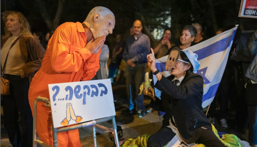 Des manifestants déguisés en Benyamin Nétanyahou et en Isaac Herzog participent à un rassemblement devant le domicile de ce dernier à Tel-Aviv, après que le premier ministre a demandé une grâce présidentielle, le 30 novembre 2025. Les bananes à leurs pieds illustrent leur dénonciation de la « République bananière » en laquelle le chef du gouvernement cherche, selon eux, à transformer Israël. Maya Levin/AFP