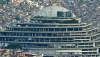  Edificio de hormigón de estilo brutalista rodeado de otros edificios. Edificio El Helicoide, en Caracas. Damián D. Fossi Salas/Wikimedia Commons