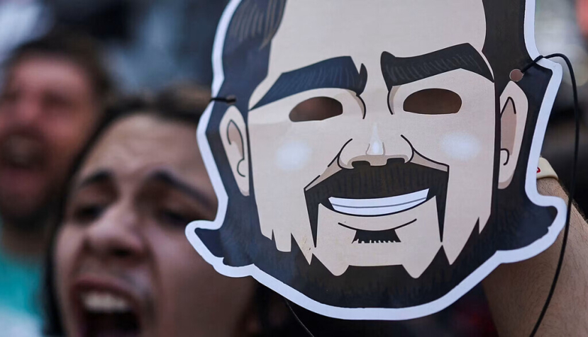 Un manifestante sostiene una máscara con la imagen de Daniel Vorcaro: el exbanquero construyó una red de influencia notable no solo por su tamaño, sino también por su ecumenismo, tanto en la derecha como en la izquierda política. Reuters/Folhapress
