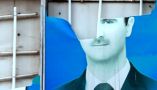 End of a half-century of family rule. A damaged portrait of Syrian President Bashar al-Assad hangs in the Syrian city of Qamishli. Delil Souleiman/AFP via Getty Images