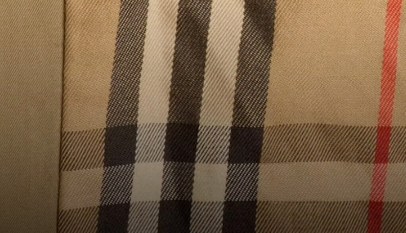 El estampado a cuadros de Burberry ilustra cómo ciertos códigos visuales se vuelven inseparables de la identidad de una marca. Museo Victoria y Alberto — Detalle del cartel de la exposición "La gabardina Burberry: Creando un icono"