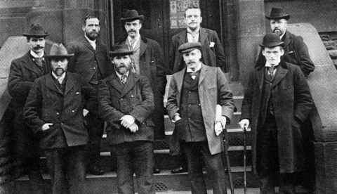 Última fila de izquierda a derecha: Ramsay MacDonald, Joseph Burgess, James Parker, J. Penny, F. Littlewood.  Primera fila, de izquierda a derecha: Bruce Glasier, Kier Hardie, H. Russell Smart, Philip Snowden.