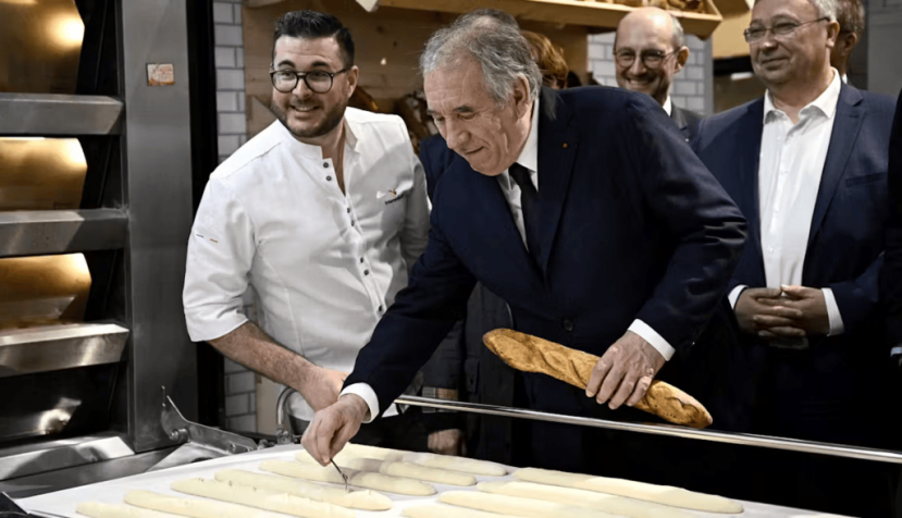 François Bayrou prépare une baguette de pain lors du Salon de l'agriculture, le 26 février 2025. Julien de Rosa / AFP