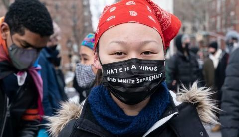 Una joven de origen asiático lleva una mascarilla que recuerda que el odio es un virus, en una manifestación en Nueva York. Lev Radin / Shutterstock