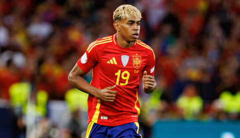  Un jugador joven corre detrás de un balón vestido de rojo, amarillo y azul durante un partido de fútbol. Lamine Yamal jugando con la selección española un partido de la Nations League en 2025. Maciej Rogowski Photo/Shutterstock