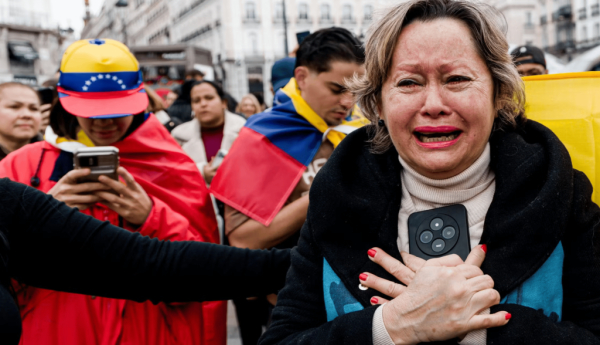  Una mujer llora con una bandera de Venezuela detrás. Unja mujer emocionada durante una manifestación de venezolanos que celebraba la caída de Maduro en Madrid. RTVE