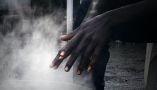 Un jeune soudanais se réchauffe les mains dans un camp de migrants à Ouistreham, dans le nord de la France. Photo prise pour un reportage de Mathieu Clavel. Lou Benoist/AFP