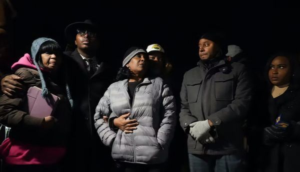 RowVaughn Wells, in gray jacket, mother of Tyre Nichols, who died after being beaten by Memphis police officers, is with friends and family members at the conclusion of a candlelight vigil for Tyre, in Memphis, Tenn., on Jan. 26, 2023. AP Photo/Gerald Herbert