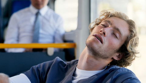 Hombre dormido en el autobús. PeopleImages/Shutterstock