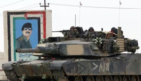 Un tanque estadounidense pasa junto a un reatrato de Saddam Hussein en marzo de 2003 en Nasiriyah, Irak. Joe Raedle/Getty Images