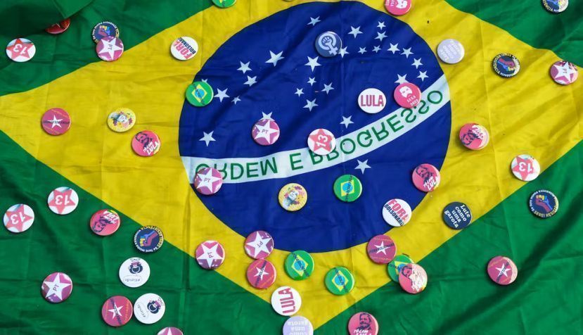 Chapas de apoyo a Lula sobre una bandera de Brasil. Shutterstock / Antonio Scorza