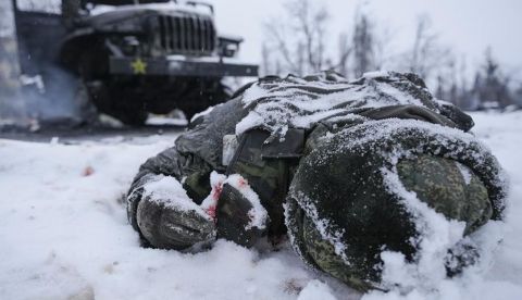 Soldado ruso caído al pie de su vehículo.