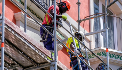  Dos hombres negros de pie sobre un andamio trabajando en la fachada de un edificio Trabajadores de la construcción en Pontevedra. Pilar Picas/Shutterstock