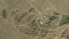  Imagen aérea de un terreno pardo con un edificio blanco en el centro Instalación de enriquecimiento de uranio de Fordow, en Irán. NASA/Wikimedia Commons, CC BY