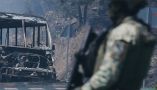 A soldier stands guard by a charred vehicle in Michoacán state, Mexico, on Feb. 22, 2026. AP Photo/Armando Solis